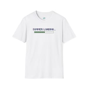 Peut inclure: Un t-shirt blanc à manches courtes avec un motif pixelisé sur la poitrine. Le texte "SUMMER LOADING..." est écrit en bleu foncé au-dessus d'une barre de progression partiellement remplie de blocs verts et partiellement vide.