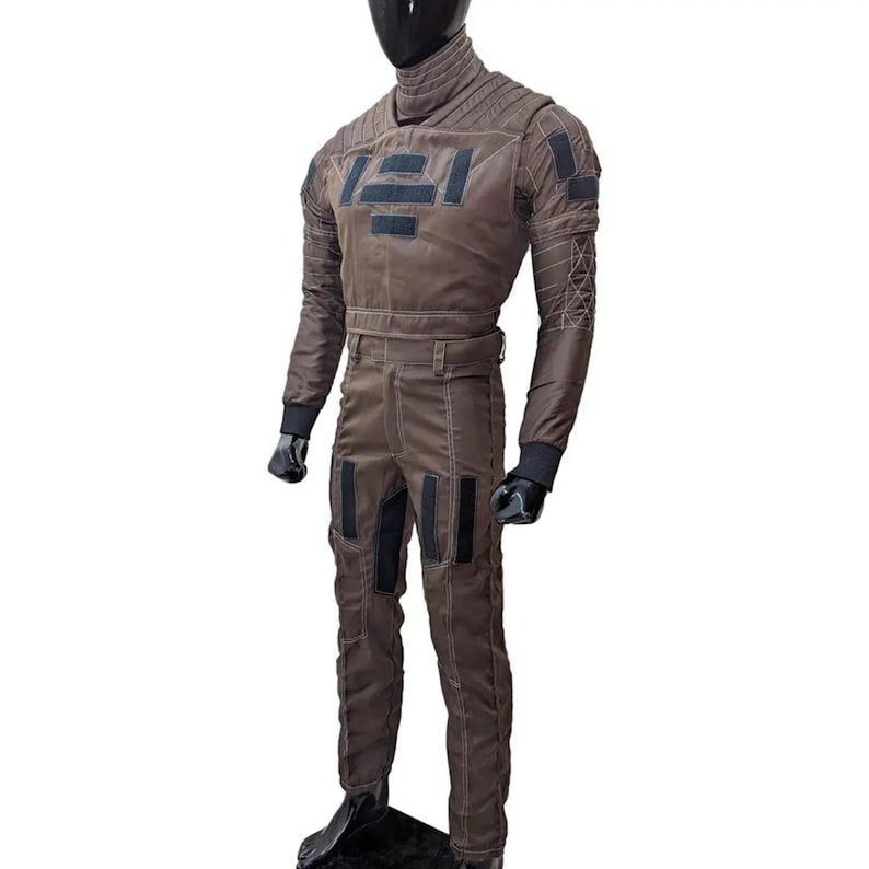 May include: Brown jumpsuit with black accents, displayed on a mannequin. The suit features a high collar, multiple patches, and a belt. Black gloves and boots complete the outfit. The jumpsuit has a futuristic design with geometric patterns.