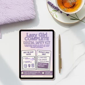 Puede incluir: Una tableta digital muestra un "Lazy Girl Complete Digital Safety Kit" con guías para principiantes. También hay un bolígrafo dorado, un cuaderno esponjoso de color lavanda y una taza de té con una ramita de lavanda.