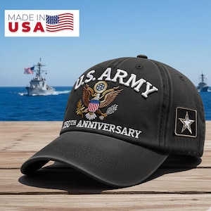 May include: Black baseball cap with "U.S. ARMY" embroidered in white, featuring an eagle emblem and a star patch. The cap commemorates the 250th anniversary. The image also shows the text "MADE IN USA" and an American flag.