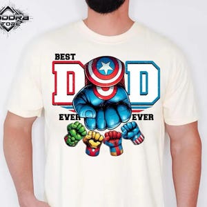 A white t-shirt with a graphic design featuring a superhero character and the text "BEST DAD EVER"