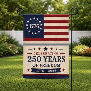 Puede incluir: Una bandera de jardín con un diseño inspirado en la bandera estadounidense, con el año 1776 rodeado de estrellas. La bandera también muestra el texto "Celebrating 250 Years of Freedom 1776-2026" en azul marino y rojo.