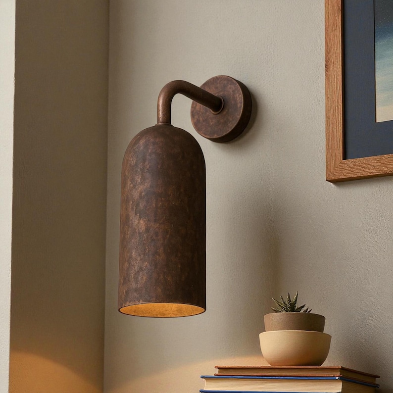 Pu&ograve; includere: Applique da parete color bronzo con paralume cilindrico e braccio curvo. L'applique &egrave; montata su una base circolare. Il paralume ha una superficie strutturata ed emette una luce dorata. Adatto per l'illuminazione interna.