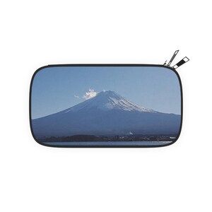 May include: A rectangular travel pouch featuring a scenic image of Mount Fuji under a clear blue sky. The mountain is snow-capped, and the image is framed by a black border. Two black zippers are visible.