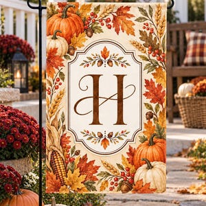 Può includere: Una bandiera da giardino rettangolare con un pannello centrale color crema e una grande lettera H marrone. Il bordo è decorato con un motivo autunnale di zucche arancioni e bianche, bacche rosse, spighe di grano, ghiande e foglie.