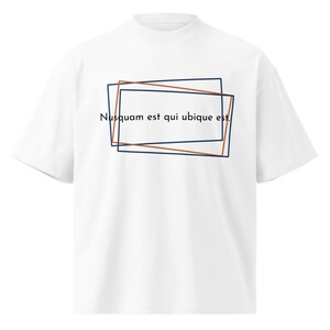 May include: White t-shirt with a mock neck and short sleeves. The shirt features a design of overlapping rectangular frames in brown and navy blue, with the Latin phrase "Nusquam est qui ubique est" printed in black.