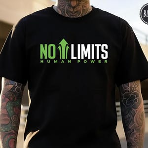 Pode incluir: Uma t-shirt preta de manga curta com o texto NO LIMITS em verde e branco, onde uma seta verde a apontar para cima substitui a letra I. Abaixo do texto principal, as palavras HUMAN POWER estão impressas em letras maiúsculas verdes.