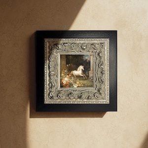 May include: A framed painting of a white horse in a garden setting. The artwork is set within an ornate silver frame, encased by a black square frame. The painting depicts a horse among flowers and greenery.