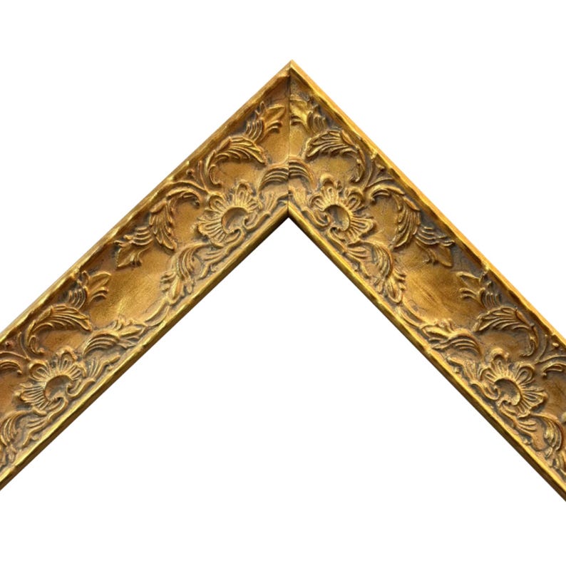 K&ouml;nnte beinhalten: Eine Ecke eines goldfarbenen Bilderrahmens. Der Rahmen hat aufwendige florale und scrollartige Details. Der Rahmen ist abgewinkelt und zeigt die komplizierten Schnitzereien und das warme, metallische Finish. Der Hintergrund ist schlicht wei&szlig;.