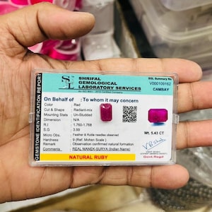 May include: A rectangular gemstone identification report for a natural ruby. The card displays the Shrifal Gemological Laboratory Services logo, a QR code, and technical data including a weight of 5.43 CT, red color, and radiant-mix cut.