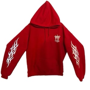 Pu&ograve; includere: Una felpa con cappuccio rossa con disegni di fiamme tribali bianche sulle maniche. La felpa ha una tasca frontale e un piccolo logo con una corona e la scritta "FTF Racing".