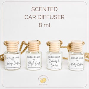 Pode incluir: Quatro pequenos ambientadores para carro de vidro com tampas de madeira e uma corda trançada. Cada frasco tem um rótulo com o texto "Smells Like" seguido de um título diferente. O texto "Scented Car Diffuser 8 ml" está no topo.