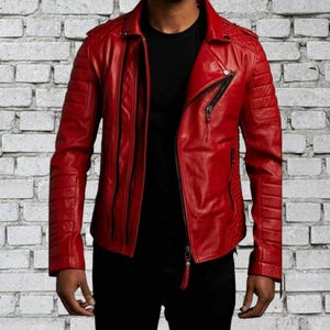 May include: A striking red leather jacket in a biker style. It has a notched collar, an off-centre zip, and quilted panels on the shoulders and sleeves. The jacket's design is sleek and modern.