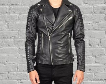 May include: Black leather jacket featuring an asymmetrical zip, quilted shoulder and sleeve panels, and silver zips. The jacket has a notched lapel collar and a tailored fit. A classic outerwear garment.