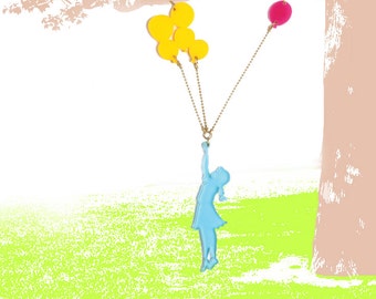 Op de afbeelding: Een blauw silhouet van een persoon die aan een gouden ketting hangt met gele en roze ballonnen eraan.