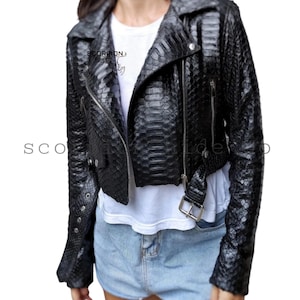 May include: Black leather jacket with a snakeskin pattern, a classic biker style with a notched collar, asymmetrical zipper, and belt detail. The jacket has the text "SCORPION" on the left side.