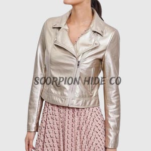 Puede incluir: Chaqueta de motero dorada metalizada. La chaqueta tiene cuello con solapas, cremallera asimétrica y un pequeño bolsillo. El texto "SCORPION HIDE CO" está impreso en la chaqueta.