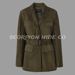 Puede incluir: Chaqueta de ante verde oliva con cinturón en la cintura, dos bolsillos en el pecho y dos bolsillos inferiores. La chaqueta tiene un cuello clásico y mangas largas. El texto "SCORPION HIDE CO" está impreso en la chaqueta.