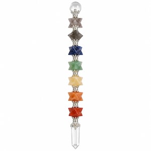 May include: A vertical wand featuring a clear crystal sphere at the top and a clear crystal point at the base. Between these ends are seven star-shaped gemstones in shades of purple, grey, blue, green, yellow, orange, and red, separated by silver-toned metal spacers.