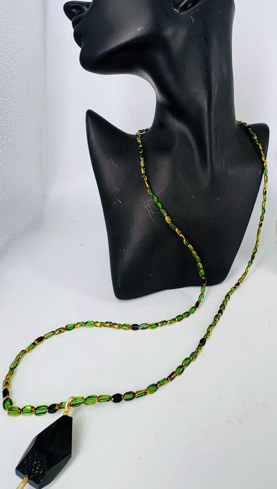 Long pendant necklace of small green and black Czech glass beads, large black bead pendant