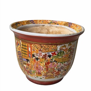 May include: A decorative ceramic planter with a wide, rounded shape. The exterior features a detailed, colourful Asian-inspired scene with figures in traditional dress. The rim is red and gold, and the interior is unglazed.