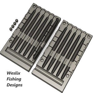 Op de afbeelding: Twee grijze vislokvormen met meerdere holtes, elk ontworpen om een specifieke lokvorm te creëren. De vormen worden vergezeld door kleine, ronde componenten. De tekst "Weslix Fishing Designs" is linksonder zichtbaar.