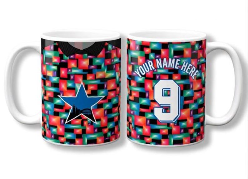 May include: Two white ceramic mugs featuring a vibrant, multi-colored geometric block pattern. The left mug displays a blue star with a black silhouette of a city skyline. The right mug features the text YOUR NAME HERE above the number 9.