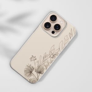 May include: A beige phone case with a floral design. The case features a clear border and a detailed illustration of delicate flowers and leaves in shades of brown. The design is on the lower left and upper right corners.
