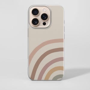 May include: A beige phone case with a rainbow design in muted colors. The rainbow arcs from the bottom left corner, featuring shades of pink, brown, and yellow. The case has a clear border and a camera cutout.