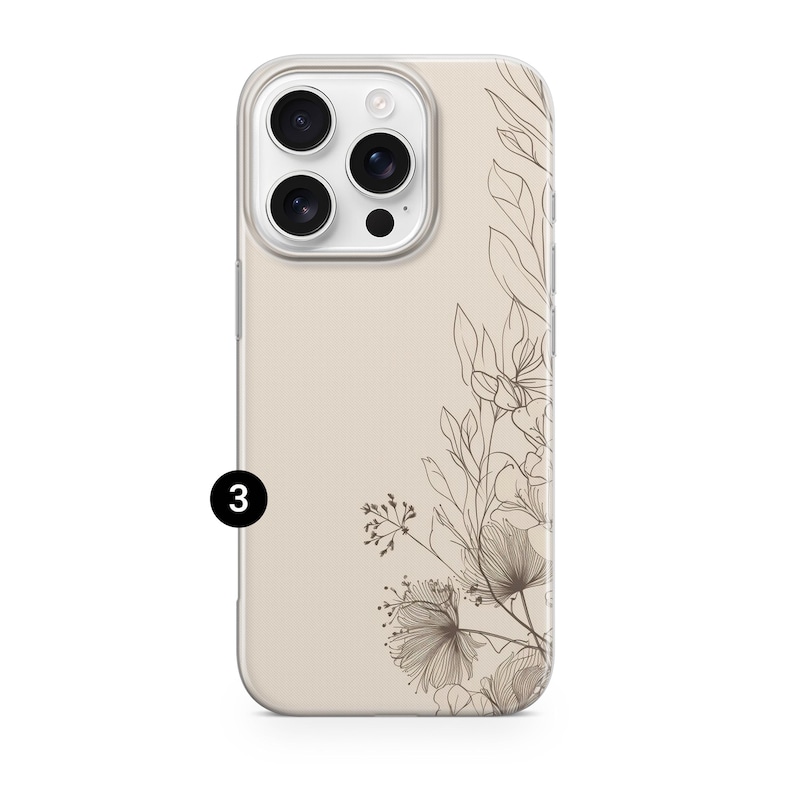 May include: A beige phone case with a floral design. The case features a clear border and a detailed illustration of flowers and leaves in shades of brown. The phone's camera lenses are visible.