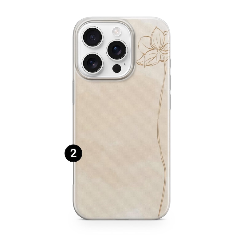 May include: A clear phone case with a beige watercolor background and a gold floral line drawing. The phone case has a camera cutout and the number "2" in a black circle.
