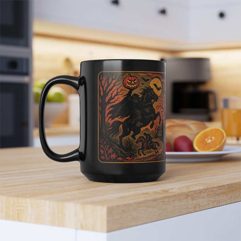 A striking mug featuring a haunting vintage-style illustration of the Headless Horseman riding beneath a full moon, pumpkin head glowing in eerie orange. The artwork captures twisted trees, bats, and gothic shadows in bold, fiery tones, wrapping around the mug for a dramatic Halloween aesthetic. Perfect for coffee, tea, or hot cider, this mug is both functional and a piece of gothic folklore art. Original design by The Haunted Hollow Co.™.