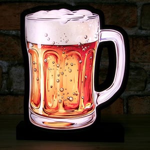 May include: A decorative illuminated beer mug with a handle, filled with amber-colored liquid and topped with white foam. The mug has a black outline and sits on a black base. The image is a stylized illustration.