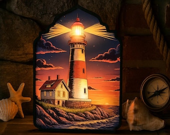 May include: A decorative framed image of a lighthouse at sunset. The lighthouse is white and red, with a bright light shining. A small house sits at the base of the lighthouse. The image is framed in a dark, ornate shape.