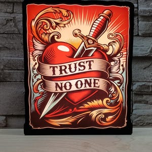 May include: A rectangular sign featuring a red heart pierced by a dagger, with a banner reading "TRUST NO ONE." The design includes ornate scrollwork and a vibrant color palette of red, orange, and gold, set against a black border.