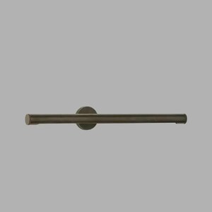 May include: A dark bronze towel bar with a circular wall mount. The bar is cylindrical and horizontal, with a slightly textured surface. The design is minimalist and modern, suitable for a bathroom or kitchen.