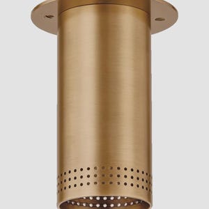 May include: A cylindrical, brass-colored recessed light fixture. The fixture has a circular base and a perforated bottom section. The overall design is simple and modern, suitable for various interior design styles. The fixture is made of metal.