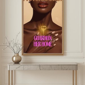 Op de afbeelding: Een ingelijst kunstwerk met de tekst "Proverbs 31:27" en "Guardian Her Home". Het kunstwerk toont een persoon met een donkere huid die een gouden sleutel vasthoudt. Het kunstwerk wordt weergegeven boven een console met marmeren blad.