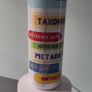 Könnte beinhalten: Ein Metallbecher mit Strohhalm und Bürste, mit den Wörtern "Information Architect", "Taxonomie" und "Referenzdaten". Das Design umfasst verschiedene farbige Etiketten und die Wörter "Data Architect" und "Information Architect".