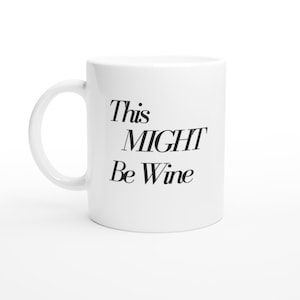 Puede incluir: Taza de cerámica blanca con asa curva. La taza presenta el texto "This MIGHT Be Wine" en negro, con letras estilizadas. La taza está diseñada para bebidas y es adecuada para uso doméstico o de oficina.