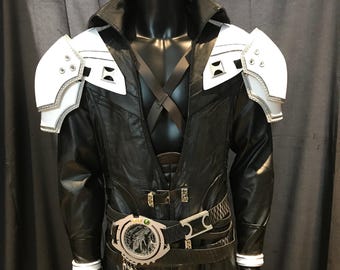 Puede incluir: Disfraz de cosplay de cuero negro con hombreras blancas y ribetes plateados. El disfraz presenta un cuello alto, un cinturón con hebilla circular y detalles decorativos. El disfraz se exhibe en un maniquí negro.
