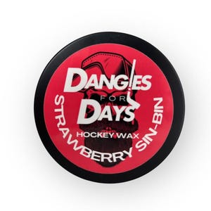 Könnte beinhalten: Ein runder, schwarzer Hockeywachsbehälter mit rotem Etikett. Das Etikett zeigt den weißen Text "DANGLES FOR DAYS", eine Totenkopf-Grafik und die Worte "STRAWBERRY SIN-BIN HOCKEY WAX".