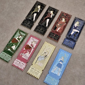 Puede incluir: Una colección de ocho pines de esmalte rectangulares con forma de entradas de concierto, cada uno con una ilustración diferente de la era de Taylor Swift. Los pines muestran varios colores, incluyendo negro, rojo, azul, verde, rosa, oro y azul claro, con el texto Taylor Swift The Eras Tour impreso en cada uno.