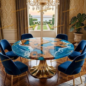 May include: A round dining table with a blue and brown epoxy resin top, supported by a gold-colored pedestal base. Six blue velvet chairs with gold legs surround the table. A chandelier hangs above, and a scenic view is visible through the window.