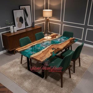 May include: A rectangular dining table with a live edge wooden top and a turquoise resin river. The table is supported by black metal legs and surrounded by six green velvet chairs. The table is approximately 183 cm long.