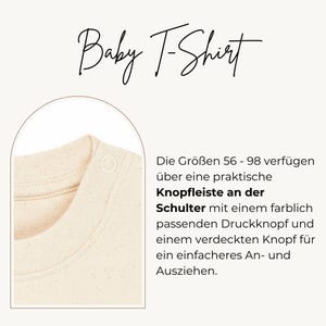 May include: A cream-coloured baby t-shirt featuring a ribbed crew neckline and a shoulder placket with a colour-matched snap button. The text reads Baby T-Shirt and includes German descriptive text regarding sizes 56-98 and the shoulder snap feature.