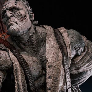 Könnte beinhalten: Detaillierte Statue von Frankensteins Monster in einer dynamischen Pose. Die Figur ist hauptsächlich grau mit strukturierten Details und trägt eine Weste und Hose. Der Hintergrund umfasst gotische Architekturelemente und brennende Kerzen.