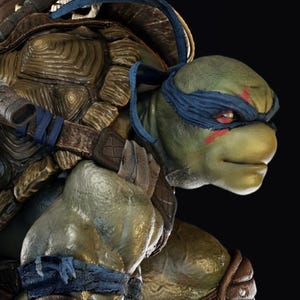 May include: A detailed statue of Leonardo, a Teenage Mutant Ninja Turtle, in a combat stance. The figure is green with a blue mask, brown armour, and two katanas on its back. The statue is on a stone base.