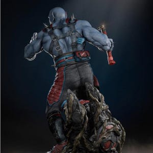 May include: A blue-skinned action figure with a muscular physique, wearing a black and red outfit with a harness and spiked shoulder pads. The figure is holding a red weapon and stands on a detailed, textured base.