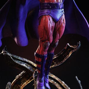 May include: A detailed action figure of a superhero, featuring a red and purple costume with a flowing cape. The figure is posed dynamically, showcasing muscular legs and boots. The base is a metallic, ornate design.